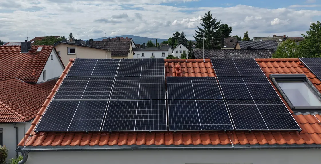 Von Moradi Elektrotechnik installierte Photovoltaik-Anlage auf einem Ziegeldach, im Hintergrund der Taunus